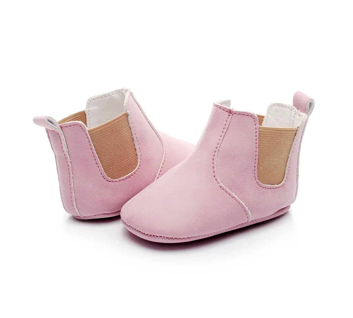Soft suede baby shoes baby xie toddler booties in soft pink suede with tan elastic side panels and white stitching.