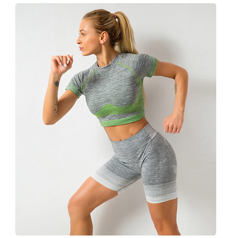 gray and green women’s seamless yoga two-piece workout set featuring a short-sleeved crop top and high-waisted hip lifting shorts designed for athletic use