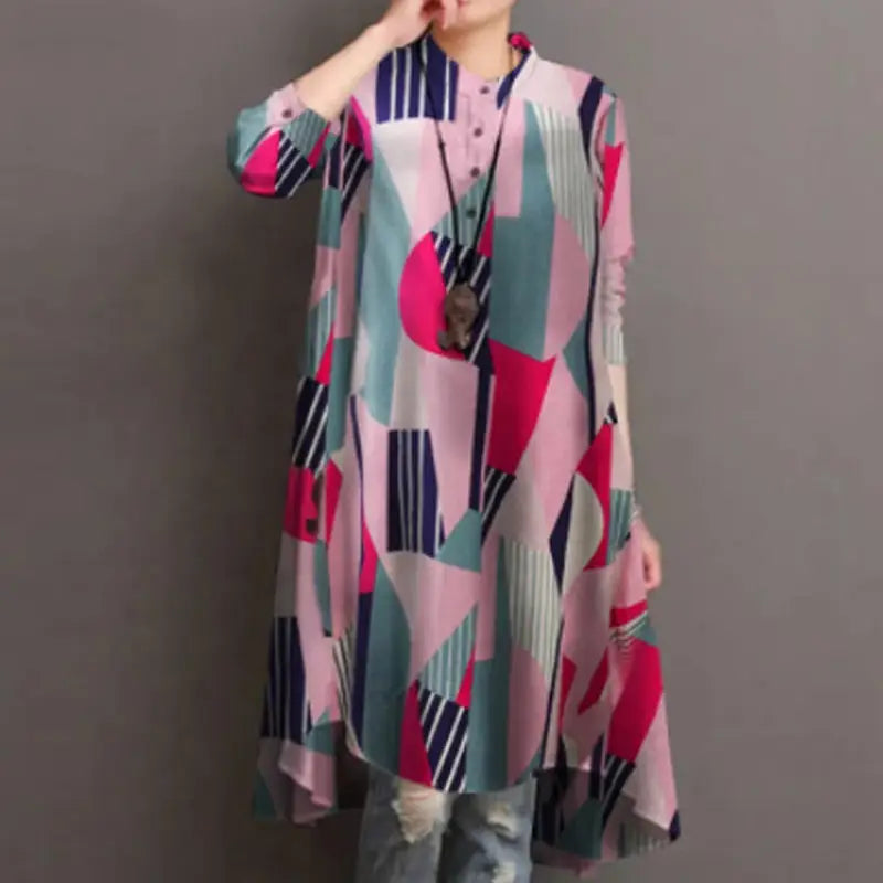 A woman wears a ladies retro casual long-sleeved sleeve loose shirt tunic dress with an abstract geometric print in pink, teal, navy blue, and white.