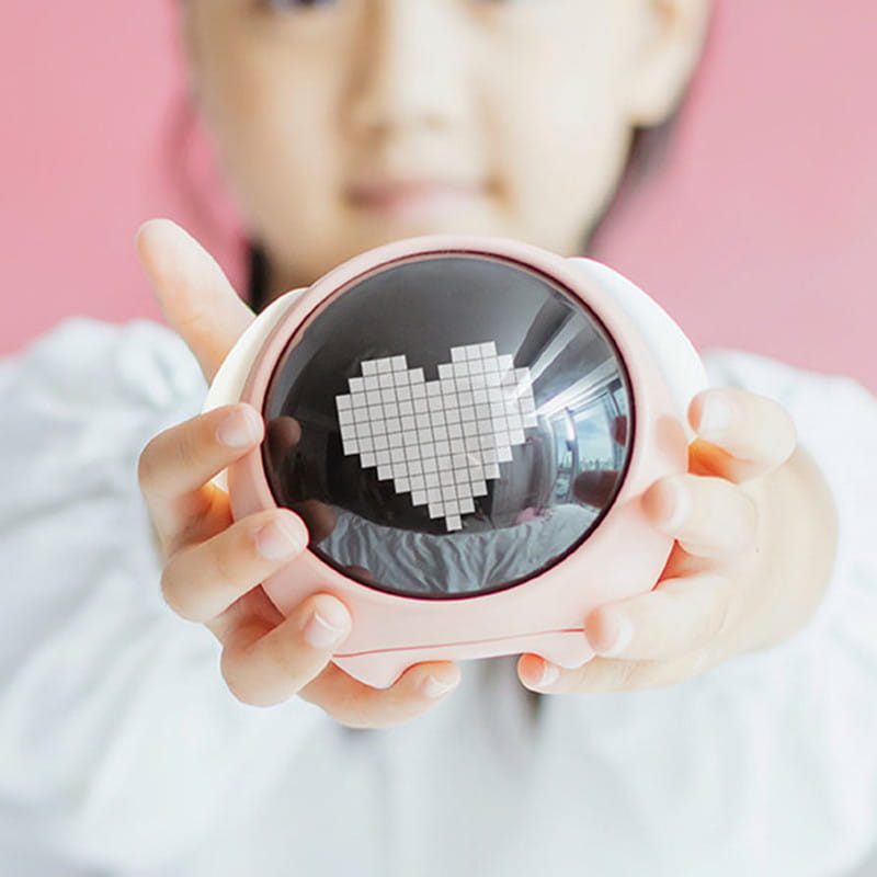 Pink circular led light projector displaying a pixelated white heart on the dark screen of a digital electronic cute pixel expression alarm clock.