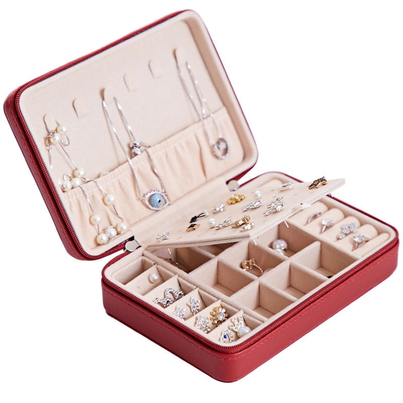 Red leather multifunctional jewelry storage box with beige interior compartments and padded sections for earrings necklaces rings and bracelets featuring a built-in mirror.