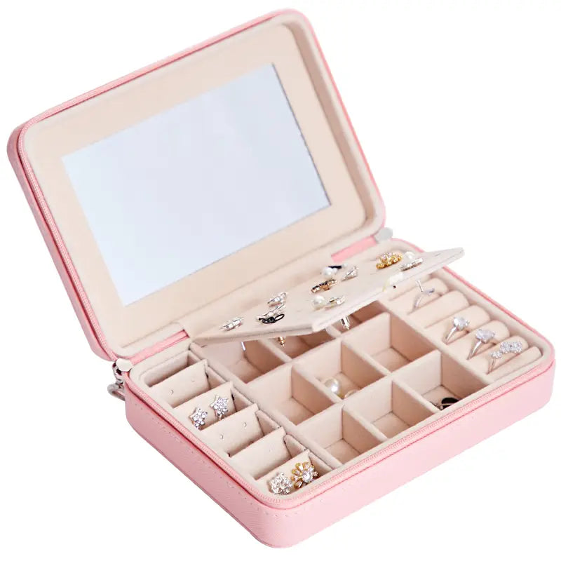 Pink leather multifunctional jewelry storage box with built-in mirror and compartments for earrings rings and other accessories for organized jewelry storage.
