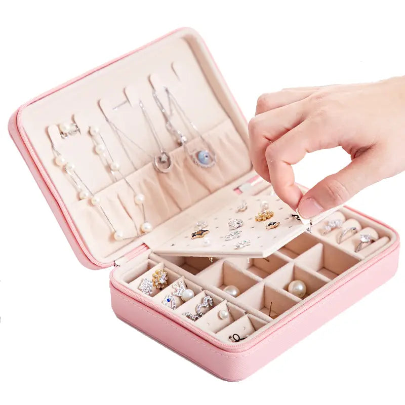 pink faux leather multifunctional jewelry storage box with cream-colored interior compartments and padded sections for earrings necklaces rings and pearls with built-in mirror