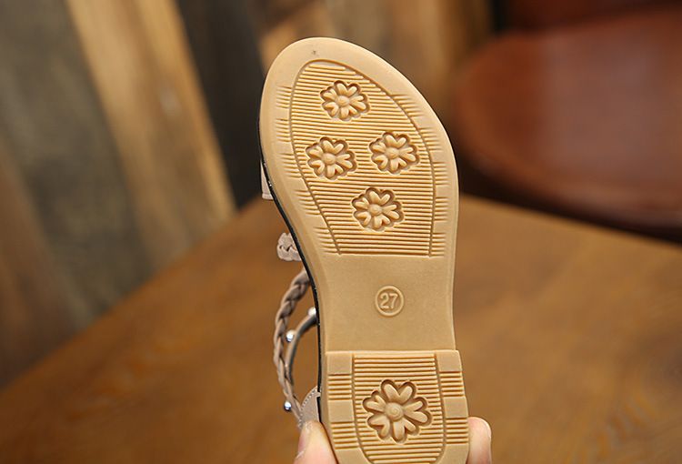 beige rubber sole with embossed floral patterns and size 27 marking of girls braided beige sandals highlighting yards internal length measurement
