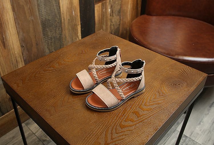 Beige braided leather girls sandals with silver-toned studded ankle straps and flat sole featuring yards internal length measurement.