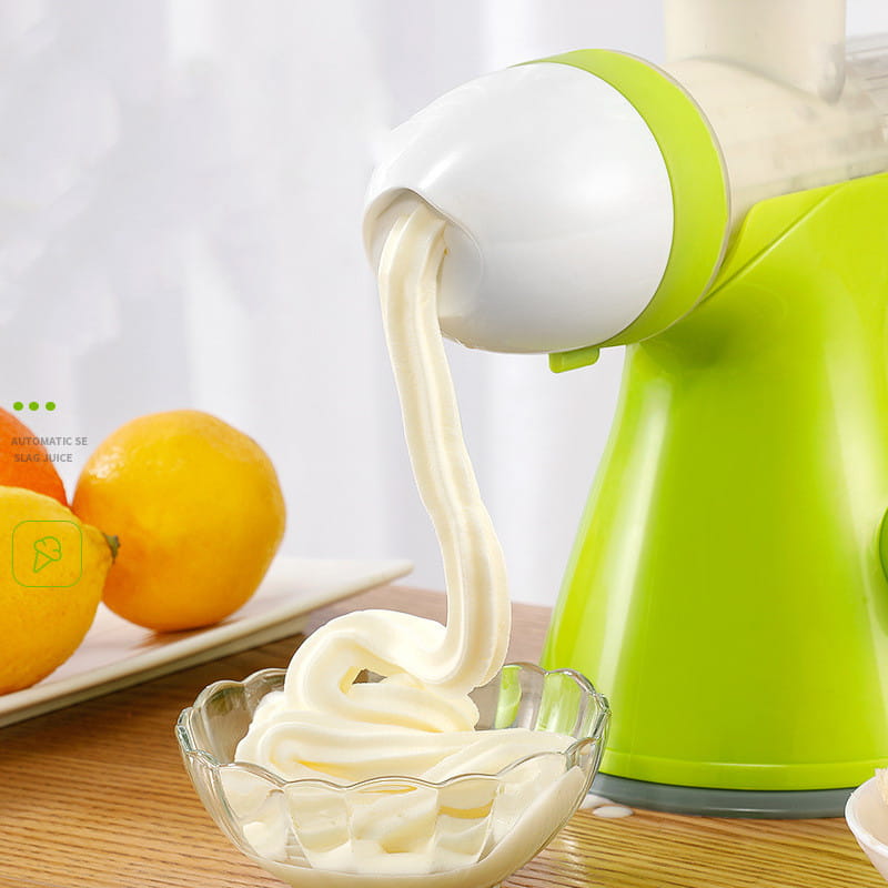 Bright green and white small household juicer automatically dispensing creamy lemon orange juice swirls into a glass bowl.