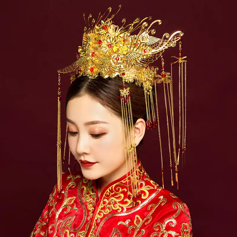 Golden ornate wedding Chinese Xiuhe headdress with ear clip featuring red gemstones and dangling chains in an elegant gift box presentation.