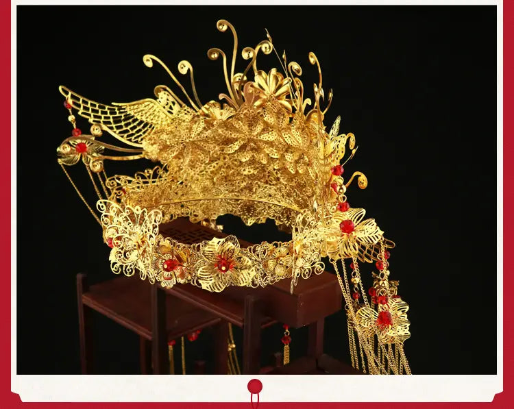 Golden ornate wedding Chinese Xiuhe headdress with ear clip featuring golden filigree, red gemstones, and intricate floral designs, elegantly presented in a gift box.