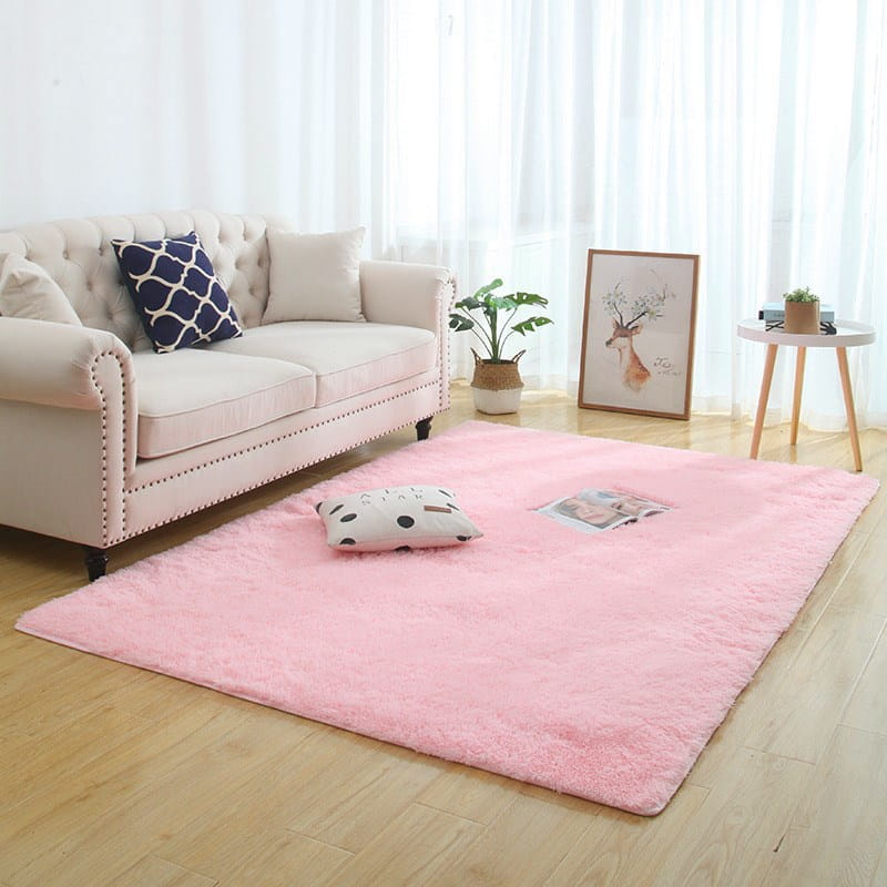 soft pink plush rectangular silky fluffy carpet with a shaggy texture placed on light wood flooring for modern home decor