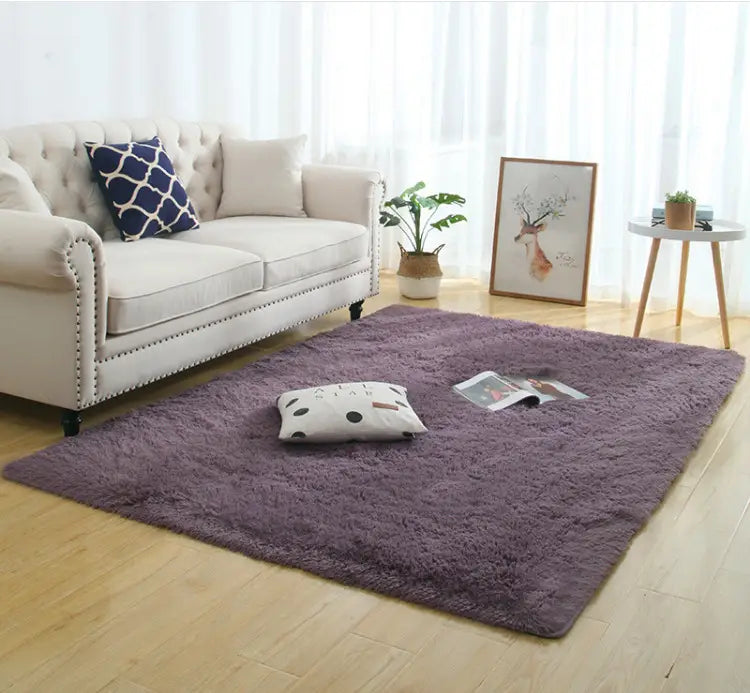 A plush deep purple shaggy area rug with a silky fluffy carpet texture and slightly raised edges for carpet modern home decor.