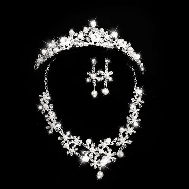 A sparkling silver alloy headdress bridal crown adorned with crystals and pearls paired with matching floral design earrings.