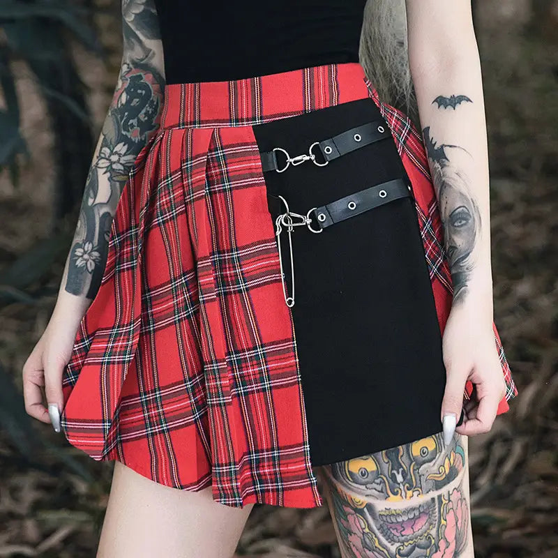 Gothic pleated short skirt in red and black plaid featuring a contrasting black panel with leather straps and metal hardware.