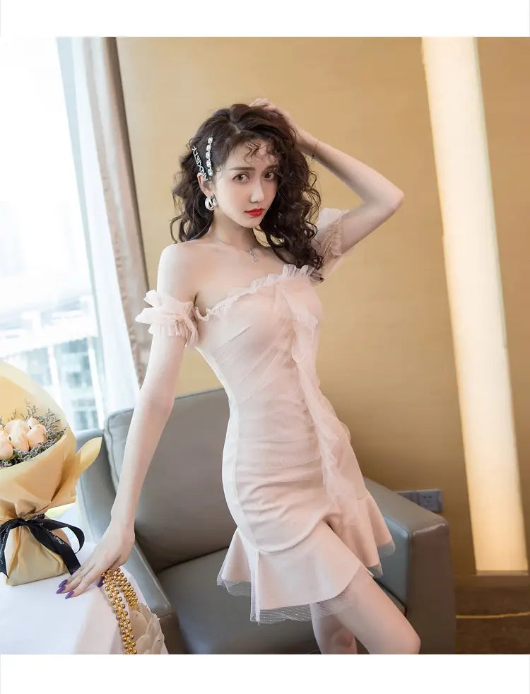 a delicate off-the-shoulder pink dress with ruffled detailing and a flared skirt designed as a sexy fishtail dress.