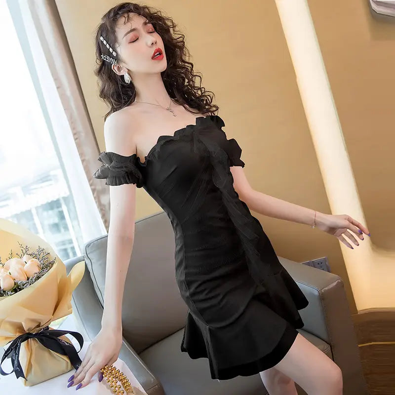 black off-the-shoulder ruffled dress with short sleeves and a flared skirt designed as a sexy fishtail dress for elegant occasions