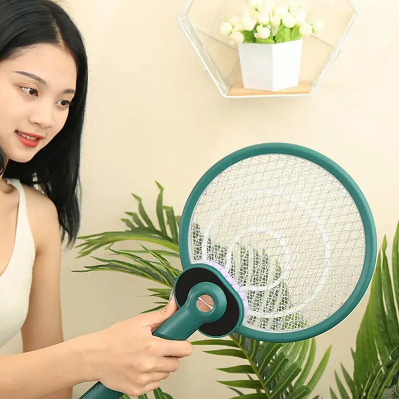 Teal plastic electric mosquito swatter with white mesh net and black rubber grip featuring mosquito trap mode for effective insect control.