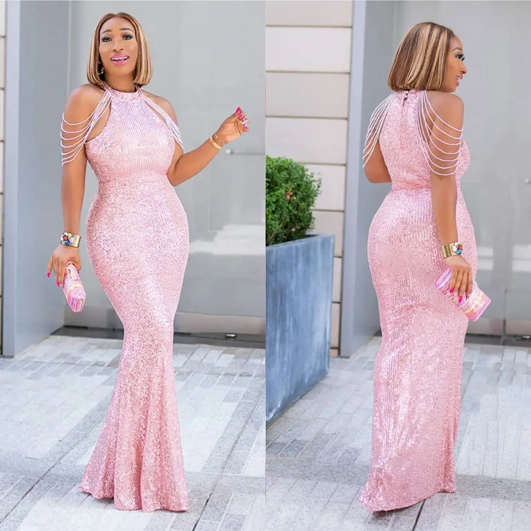 A shimmering pink sequined mermaid gown with delicate shoulder straps and a halter neckline showcasing african ladies quality high stretch fabric.