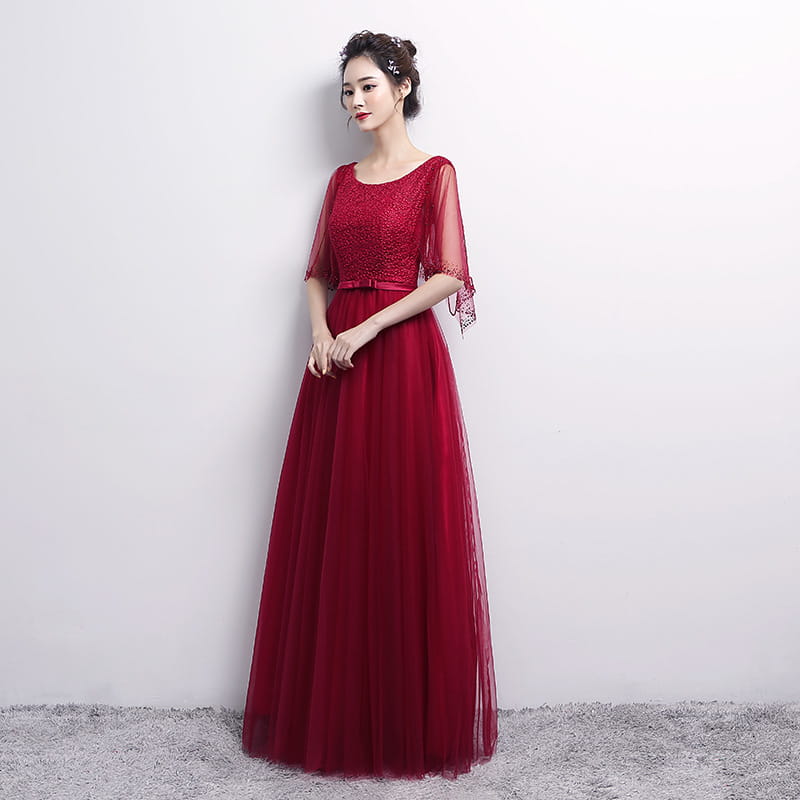 A woman wears a deep red banquet evening dress with an embellished bodice and sheer three-quarter sleeves suitable as an evening dress female or dress female spring.