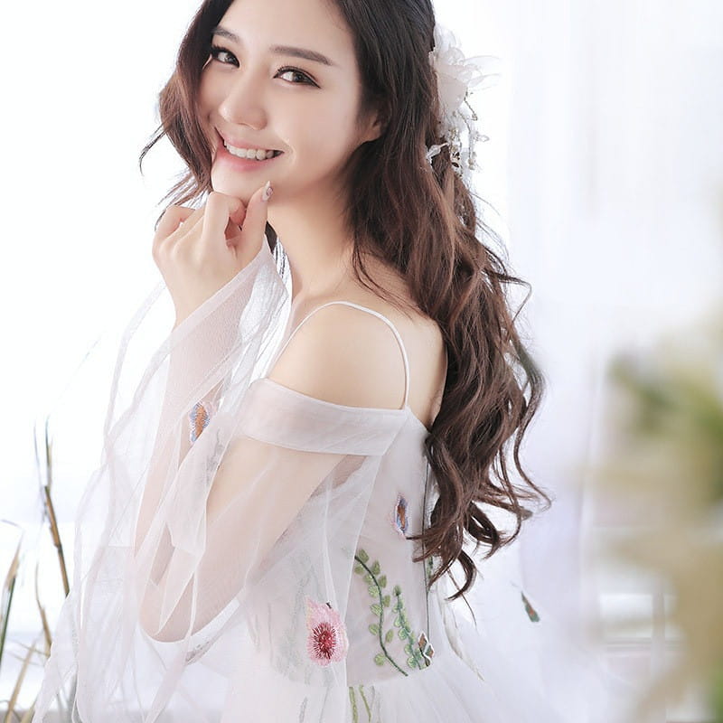a delicate white sheer overlay wedding dress with floral embroidery and thin straps in gray tulle retro bridal gown super