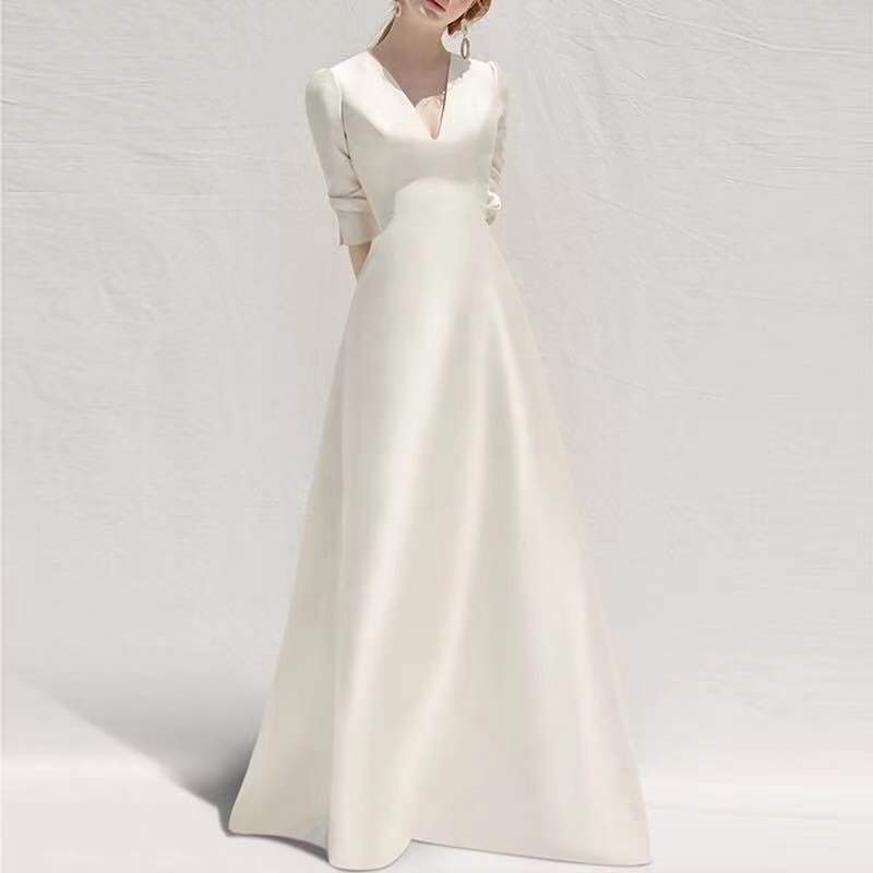 Elegant ivory satin white satin v neck wedding dress with polyester fiber fabric, v-neckline, three-quarter sleeves, and a long skirt.