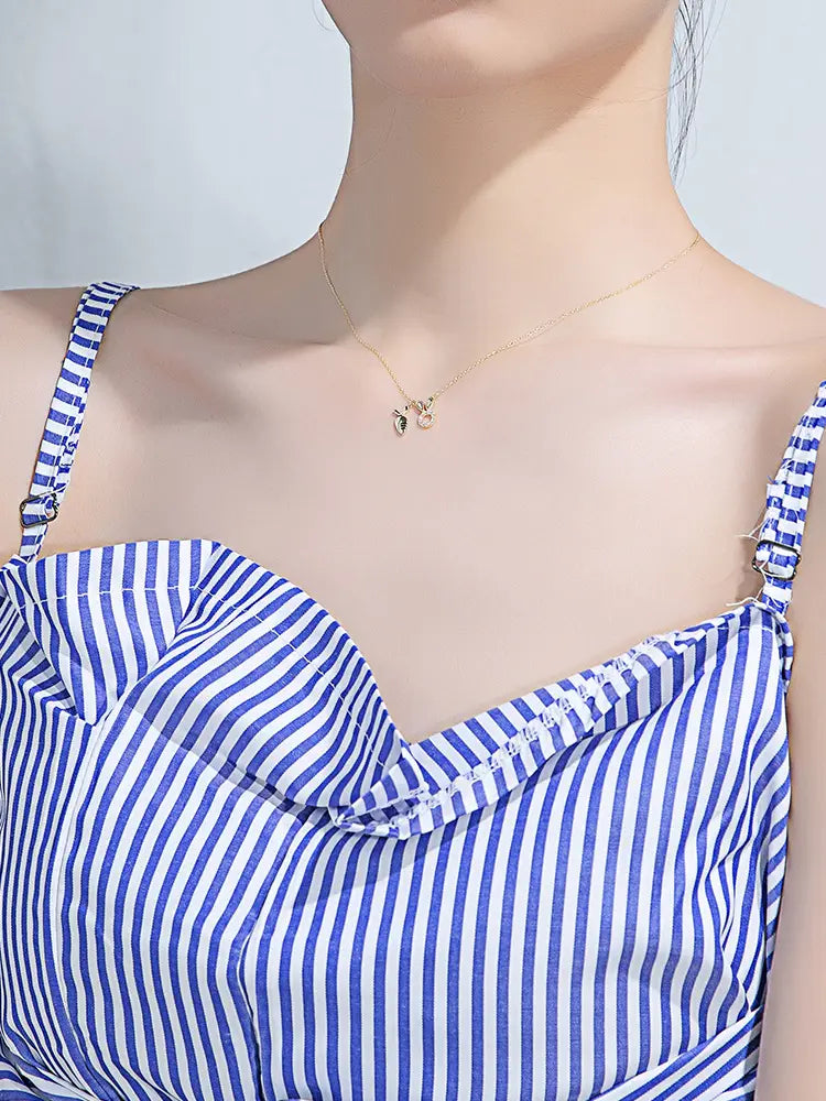 A delicate 18k gold plated rabbit pendant necklace with a small intricate gold pendant featuring two intertwined leaf designs.