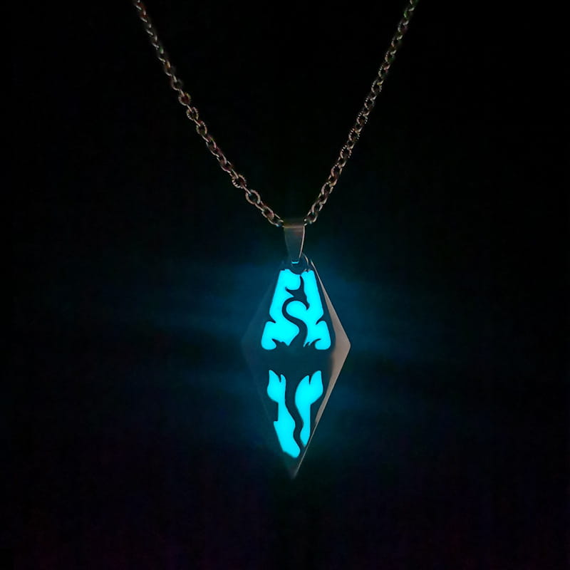 A glowing blue diamond-shaped titanium steel luminous necklace pendant with intricate black patterns suspended from a silver chain designed as couple jewelry.