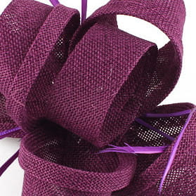 A deep purple woven fascinator with a textured fabric finish and subtle shimmer designed as ladies banquet ball hair accessories.