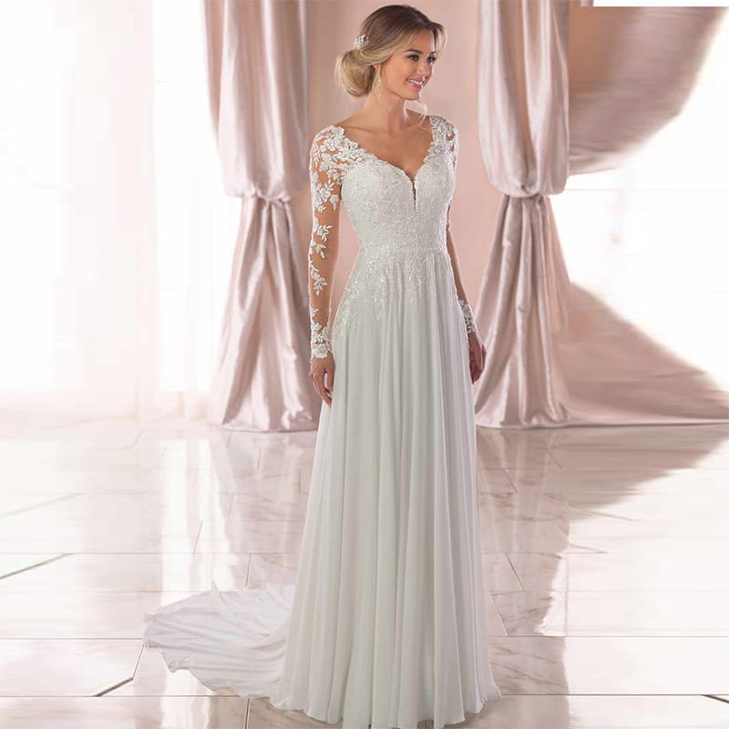 A flowing white wedding dress with intricate lace detailing on the long sleeves and bodice, featuring a sexy backless deep v-neckline and a soft sheer skirt.