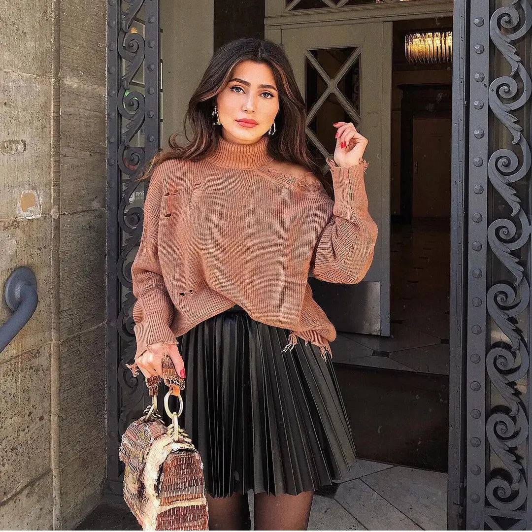 a textured earth toned draped pleated knitted mini skirt featuring intentional distressed holes and frayed edges made from soft knit material