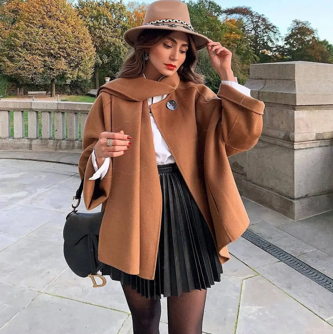alt text: tan woolen coat with a hood and decorative belt detail paired with a draped pleated knitted mini skirt showcasing pleated knitted mini skirt design