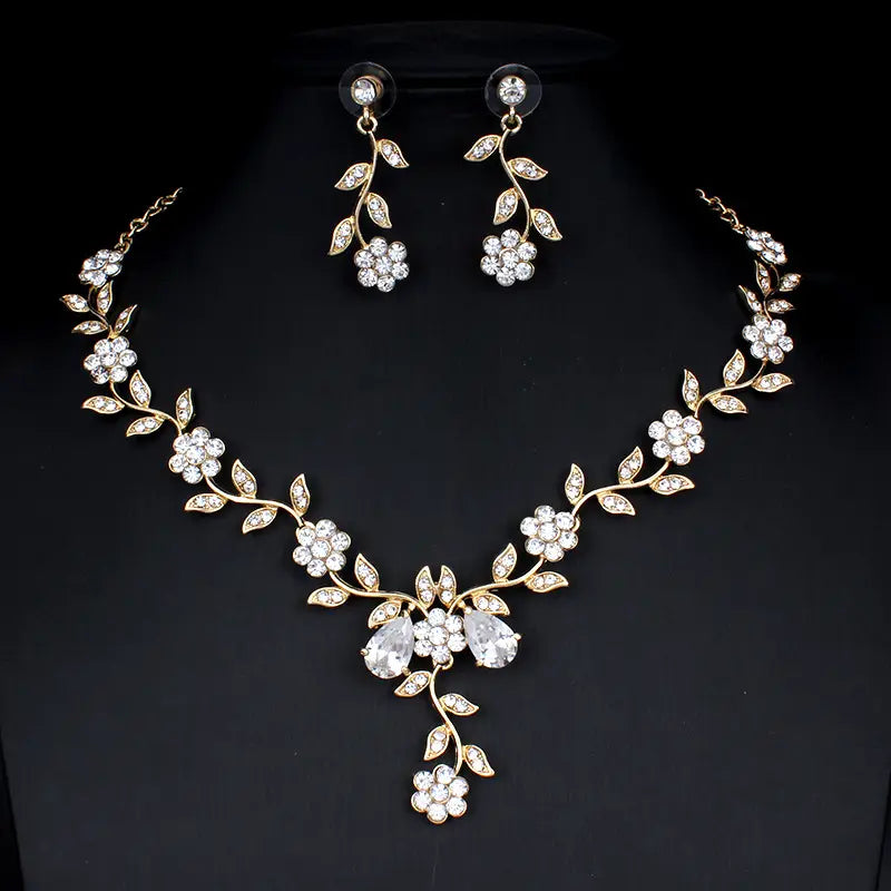 gold-toned floral necklace and matching earrings adorned with clear crystals as part of a golden zircon jewelry set for bridal use