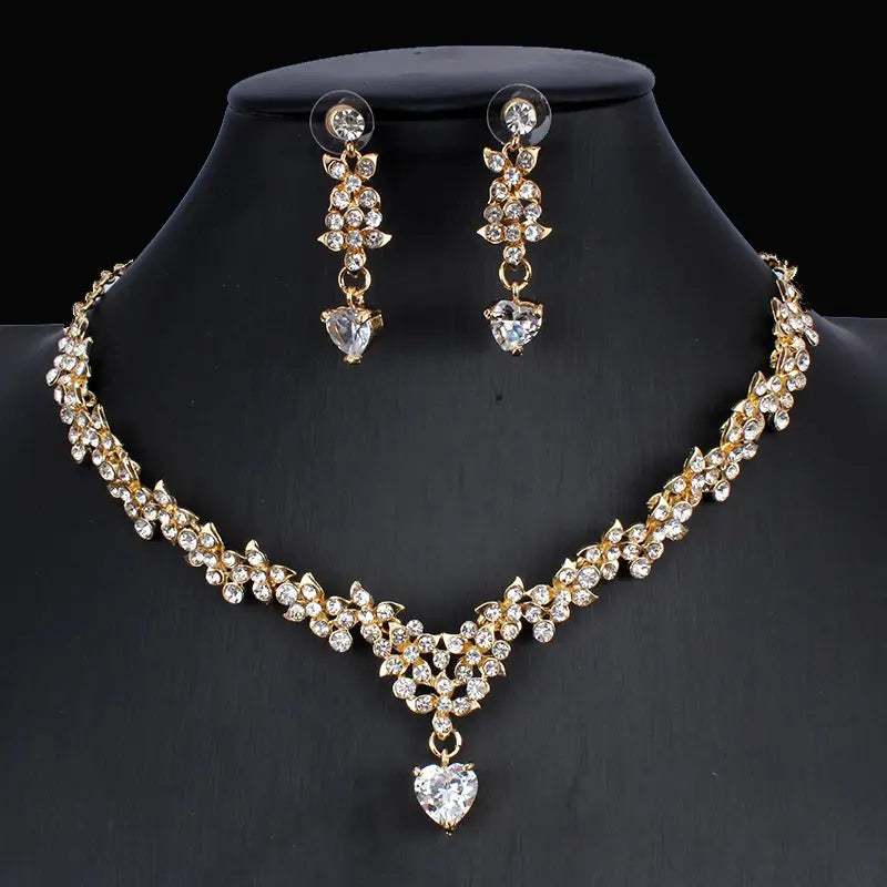 Golden zircon jewelry set featuring a gold-toned bridal floral necklace adorned with clear crystals and a heart-shaped pendant, paired with matching earrings.