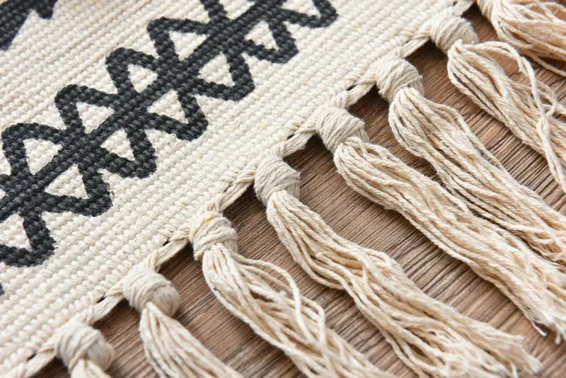 beige scandinavian style linen cotton rug with black geometric pattern and macrame fringe tassels