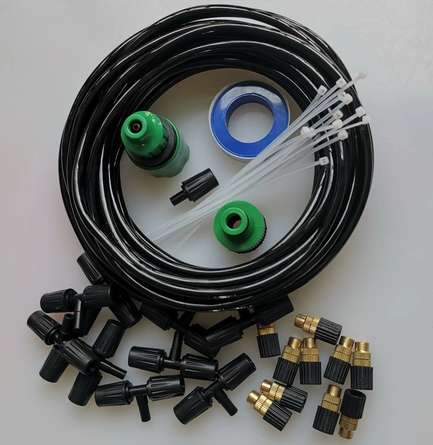 black coiled garden hose with green and brass lock type copper fittings, black plastic connectors, white zip ties, and a blue o-ring for the lock type copper outdoor misting system