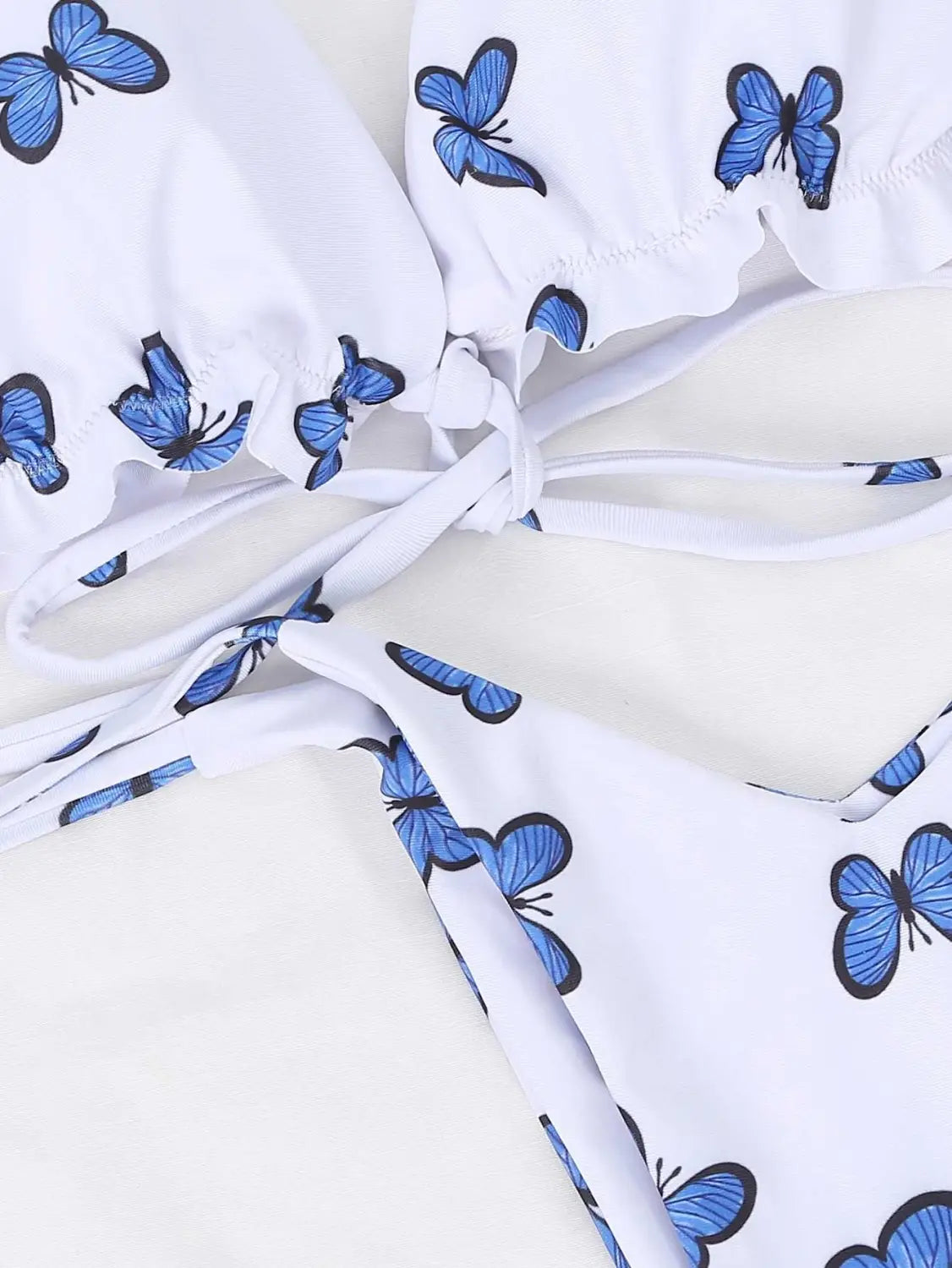 white bikini top with blue butterfly prints and ruffled edges from a butterfly print swimsuit lace thong set in lightweight fabric