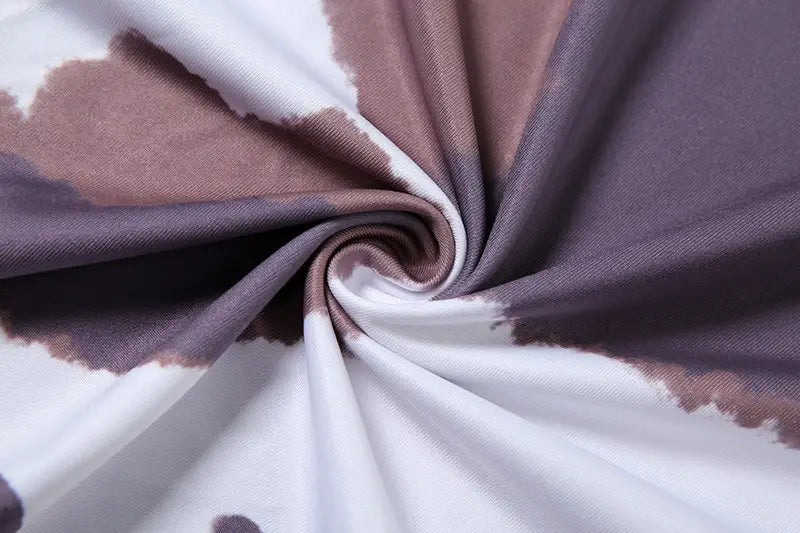 a women irregular hole maxi dress made of soft flowing fabric with a modern tie-dye cow print pattern in muted white taupe and gray hues featuring weird puss hollow design details