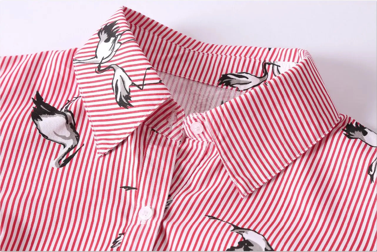 Long sleeve striped shirt dress in pink and white featuring a playful black and white stork pattern suitable for long sleeve women’s fashion.