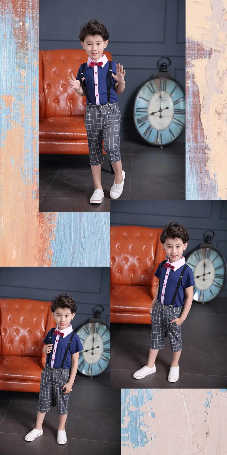 A young boy wearing a men’s plaid suspenders treasure suit tide suit with a navy blue short-sleeved shirt, gray and black plaid cropped pants, and a red bow tie.
