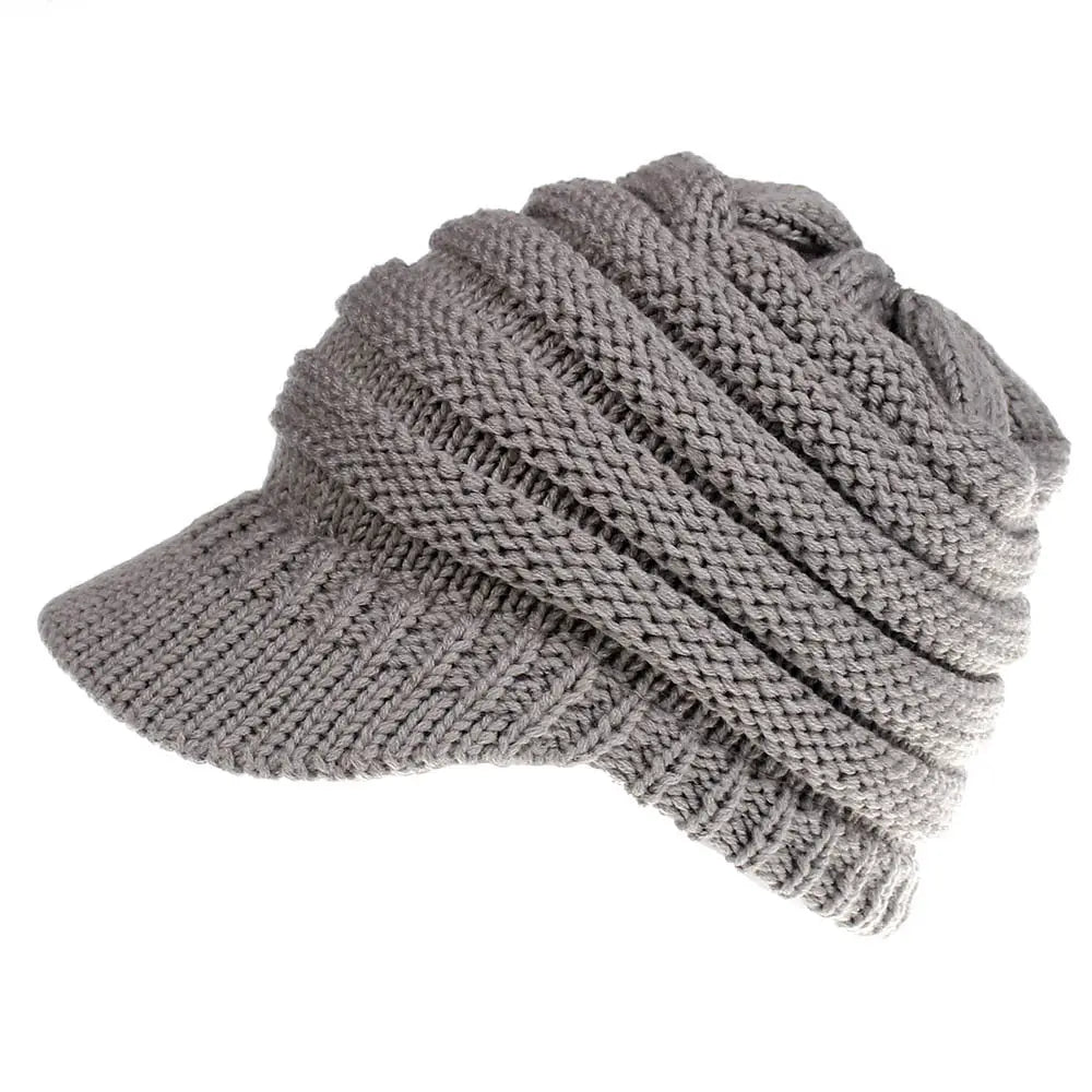 a cozy medium-gray knitted women ponytail beanie with a structured brim and ribbed texture suitable for autumn and winter use