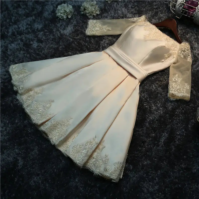 a cream satin cocktail evening dress bride featuring delicate gold lace trim along the neckline sleeves and hemline designed for dress bride wedding and bride wedding toast occasions