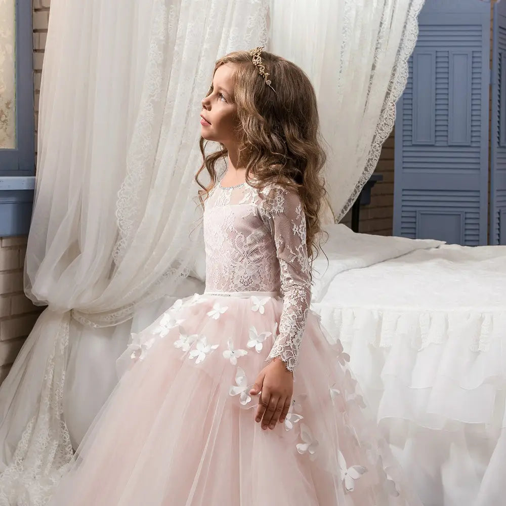 A delicate pink tulle girls pengpeng skirt adorned with white lace sleeves and floral appliqués perfect for special occasions.