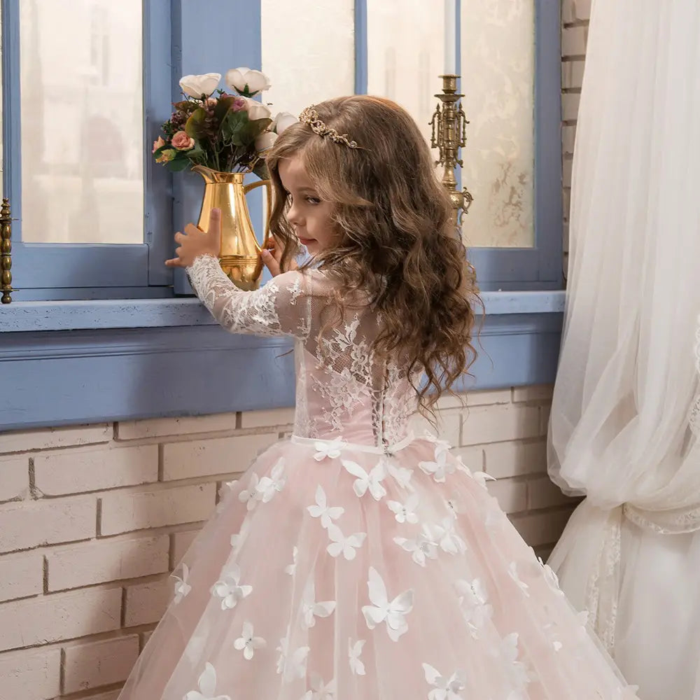 a delicate pink lace girls pengpeng skirt adorned with white butterfly appliqués and featuring long sheer sleeves