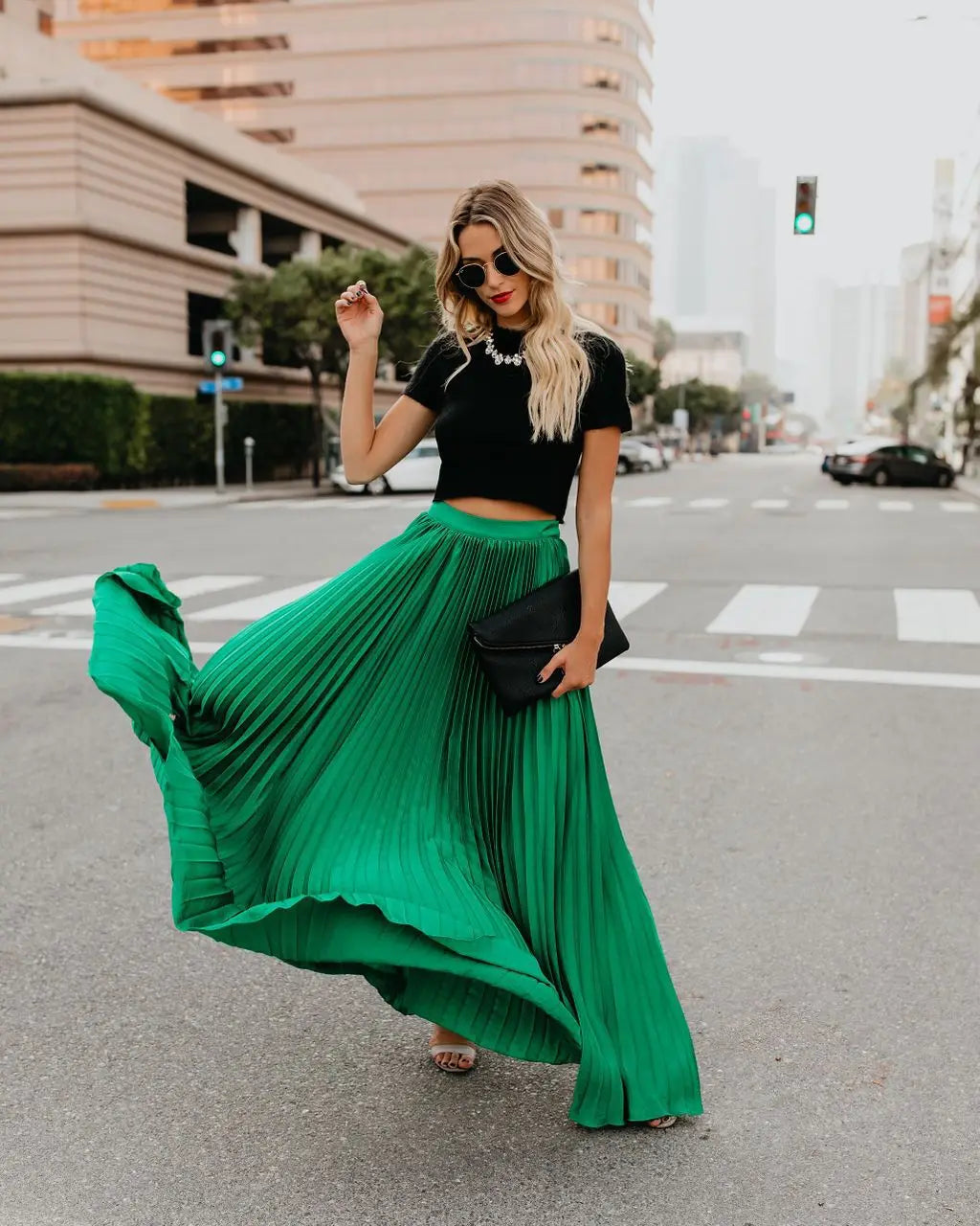 A flowing emerald green pleated maxi skirt with a high waist and flared hem showcasing women fashion casual style and skirt length.