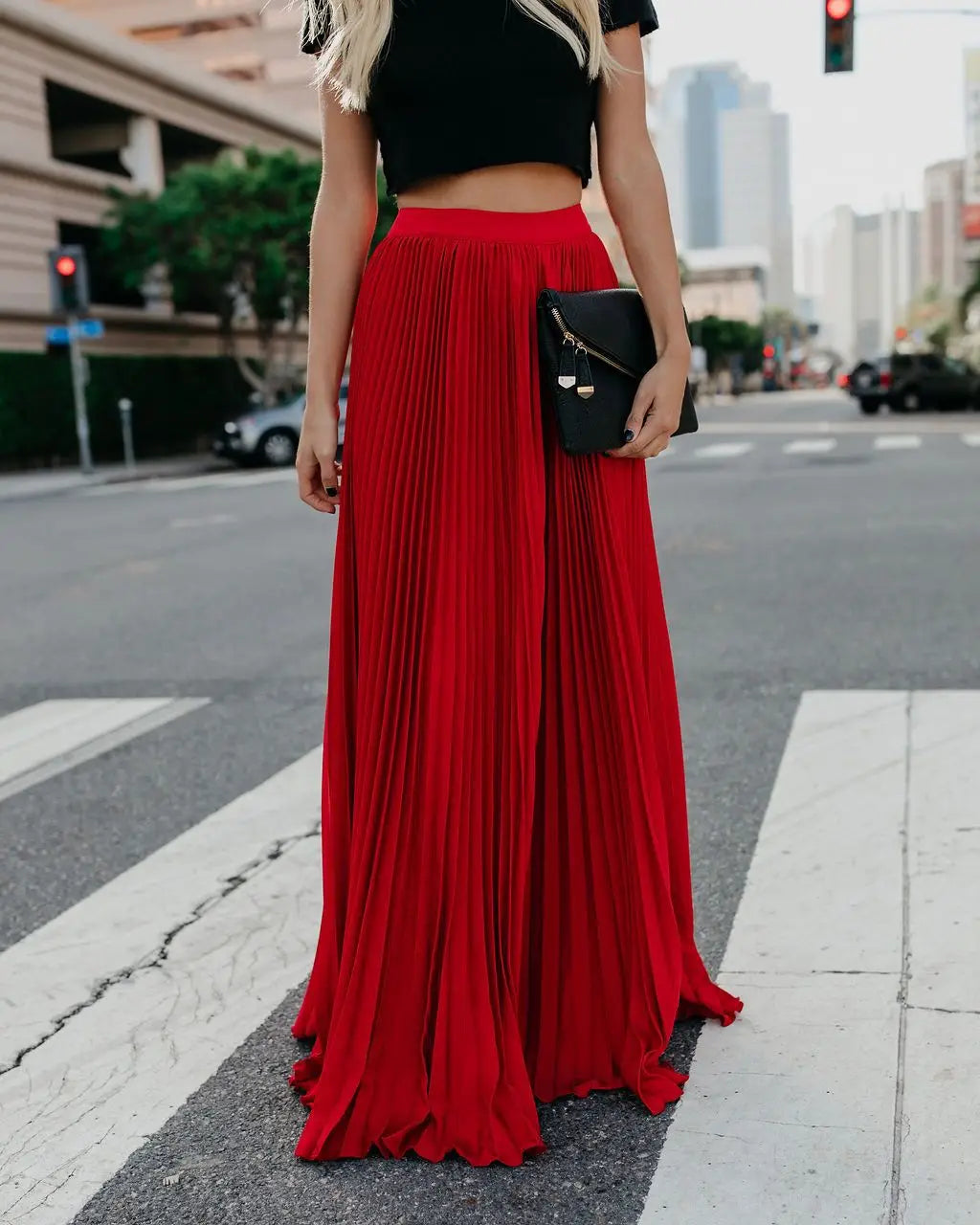 A vibrant red pleated high waist women fashion casual skirt with a floor-length skirt length and flowing elegant drape.
