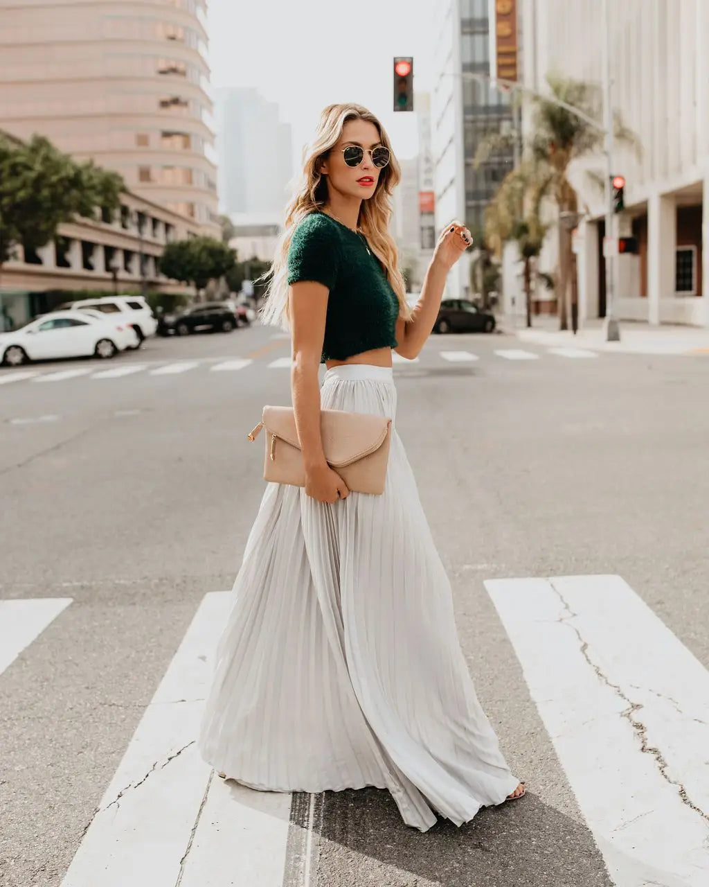 Beige leather clutch with a minimalist envelope design complementing a red pleated high waist women fashion casual skirt with a flattering skirt length.