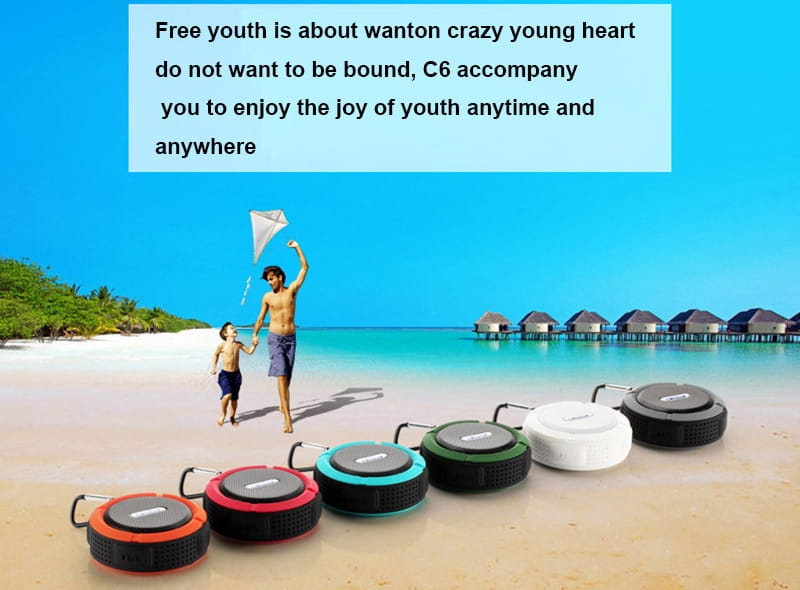 a row of colorful circular teal and black portable waterproof speakers with rugged exteriors and carabiner hooks designed for outdoor use and travel accessories