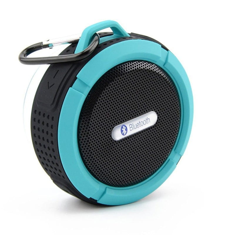 Teal and black portable waterproof speaker with carabiner clip designed for outdoor use and convenient carrying.