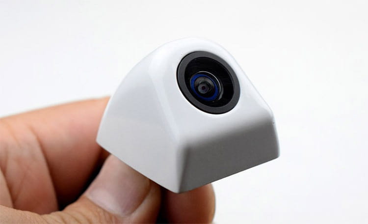 white compact camera lens with black circular aperture and blue-tinted glass on 4.3 inch led rear view mirror with reversing camera