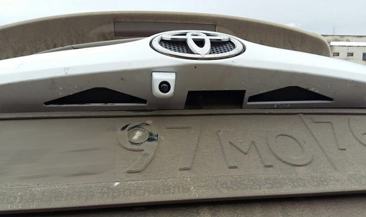 Silver Toyota emblem with chrome finish mounted on a vehicle rear bumper shown from the back side related to a 4.3 inch LED rear view mirror with reversing camera product.