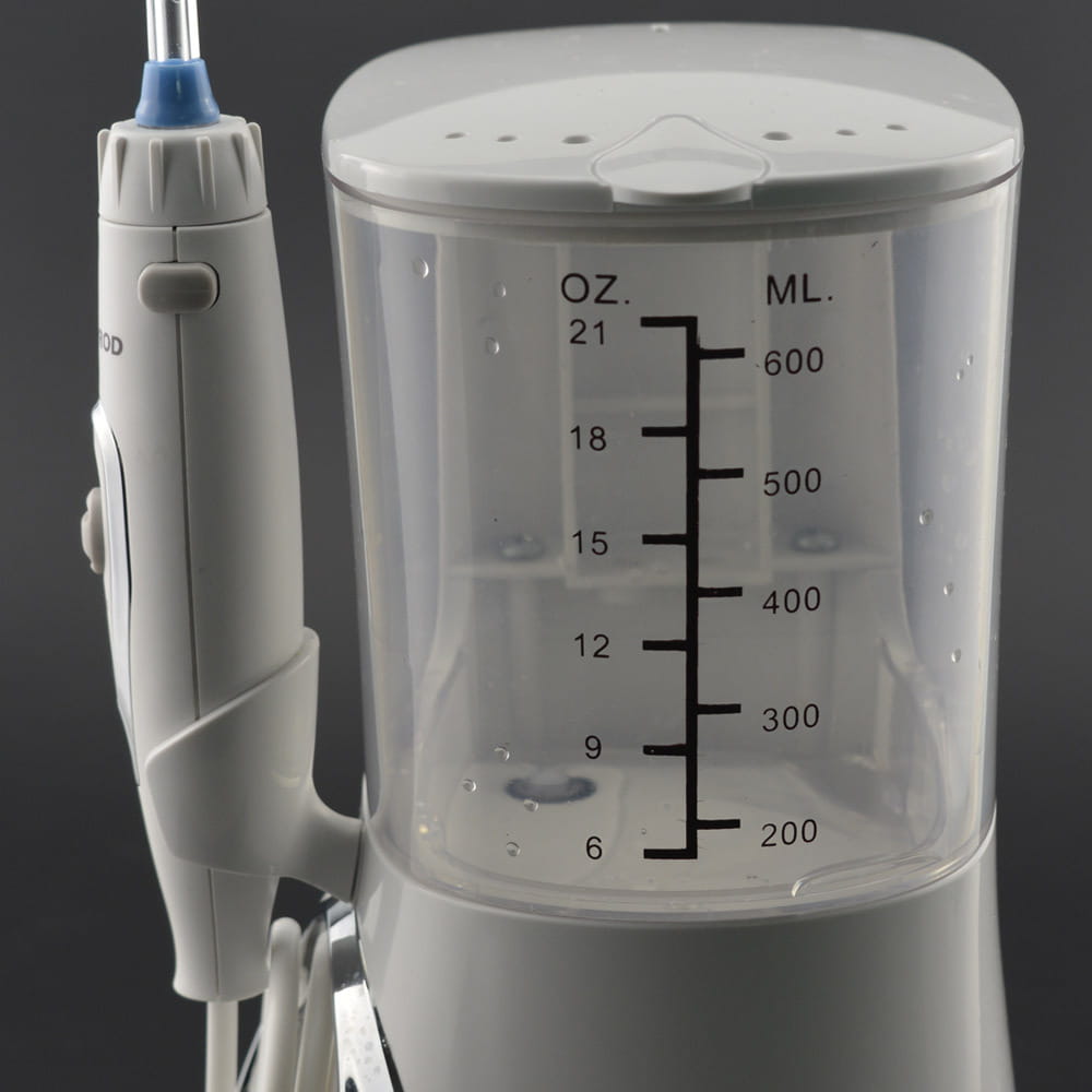 Modern electric tooth punch electric tooth flosser in white with a transparent reservoir marked in ounces and milliliters and a blue-tipped brush head nozzle.