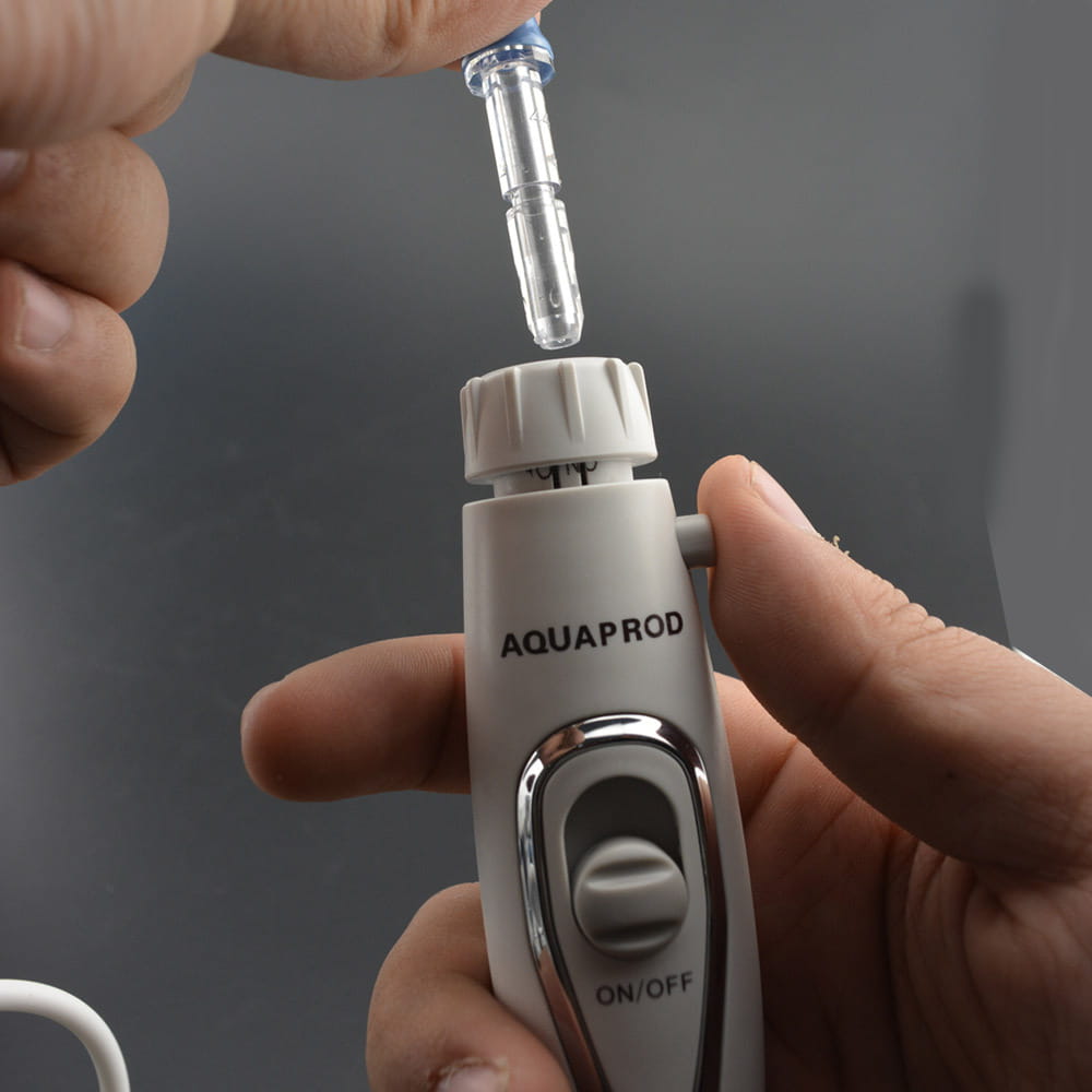 A white and silver Modern Electric Tooth Punch electric tooth flosser with a clear tank and a transparent brush head tip held above the device.